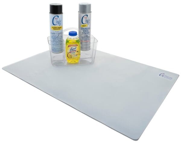 Three cleaning products in a container on a mat